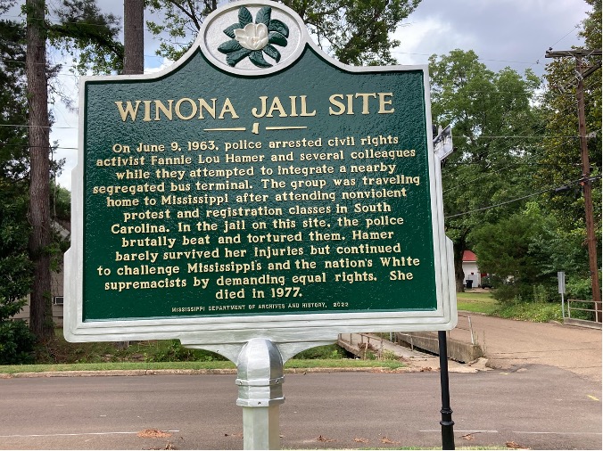 Historical marker of jail site where civil rights activist Fannie Lou Hamer was taken on June 9, 1963. Sign reads, "On June 9, 1963, police arrested civil rights activist Fanning Lou Hamer and several colleagues while they attempted to integrate a nearby segregated bus terminal. The group was traveling home to Mississippi after attending nonviolent protest and registration classes in South Carolina. In the jail on this site, the police brutally beat and tortured them. Hamer barely survived her injuries but continued to challenge Mississippi and the nations white supremacist by demanding equal rights. She died in 1977."